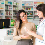 Pharmacy technician helping a customer in the pharmacy with medications