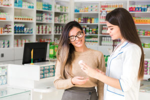 Pharmacy technician helping a customer in the pharmacy with medications